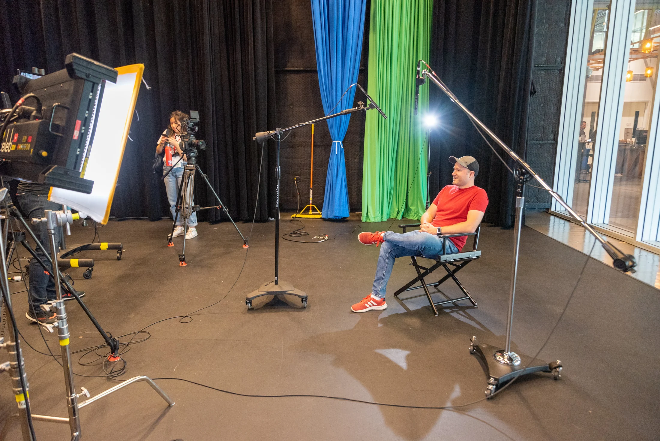 Tim Schmoyer seated in a professional video production studio beneath a boom microphone
