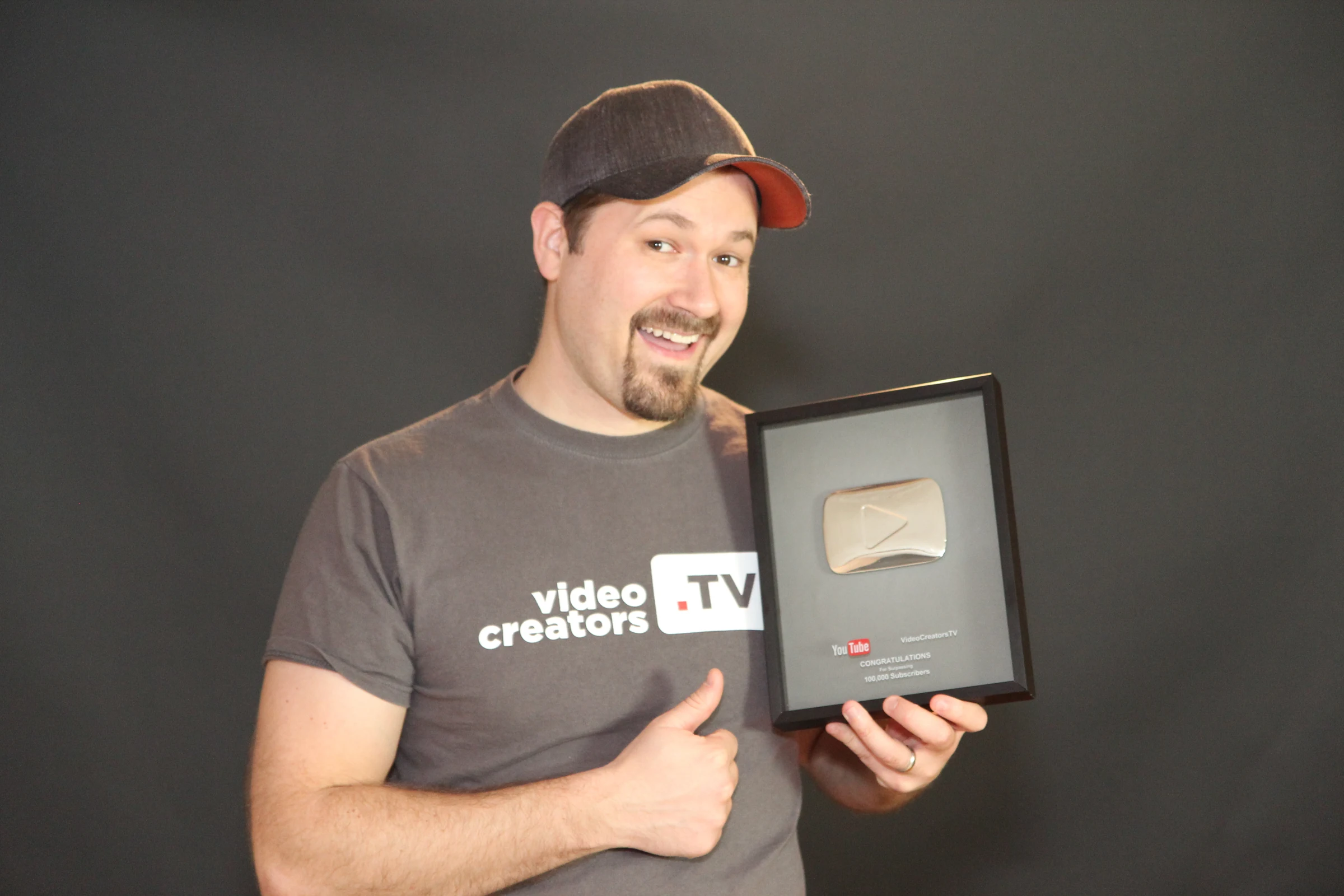 Tim Schmoyer wearing a Video Creators shirt and holding the channel's YouTube Silver Creator Award